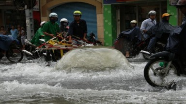 TPHCM: Mưa làm bung nắp cống, gây ngập nặng