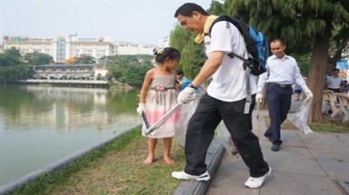 Nhiều người nhặt rác bên Hồ Gươm