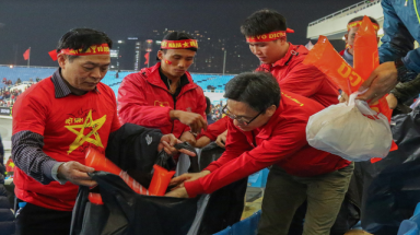 Phó Thủ tướng Vũ Đức Đam tham gia dọn rác sau trận đấu tại Mỹ Đình