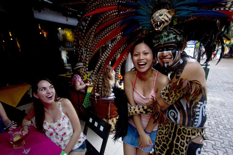 Canadian[-]tourists[-]pose[-]for[-]a[-]picture[-]with[-]a[-]Mexican[-]man[-]wearing[-]a[-]pre-hispanic[-]costume[-]at[-]a[-]tourist[-]area[-]of[-]Playa[-]del[-]Carmen[-]in[-]Quintana[-]Roo[-]state,[-]Mexico,[-]on[-]December[-]18,[-]2012